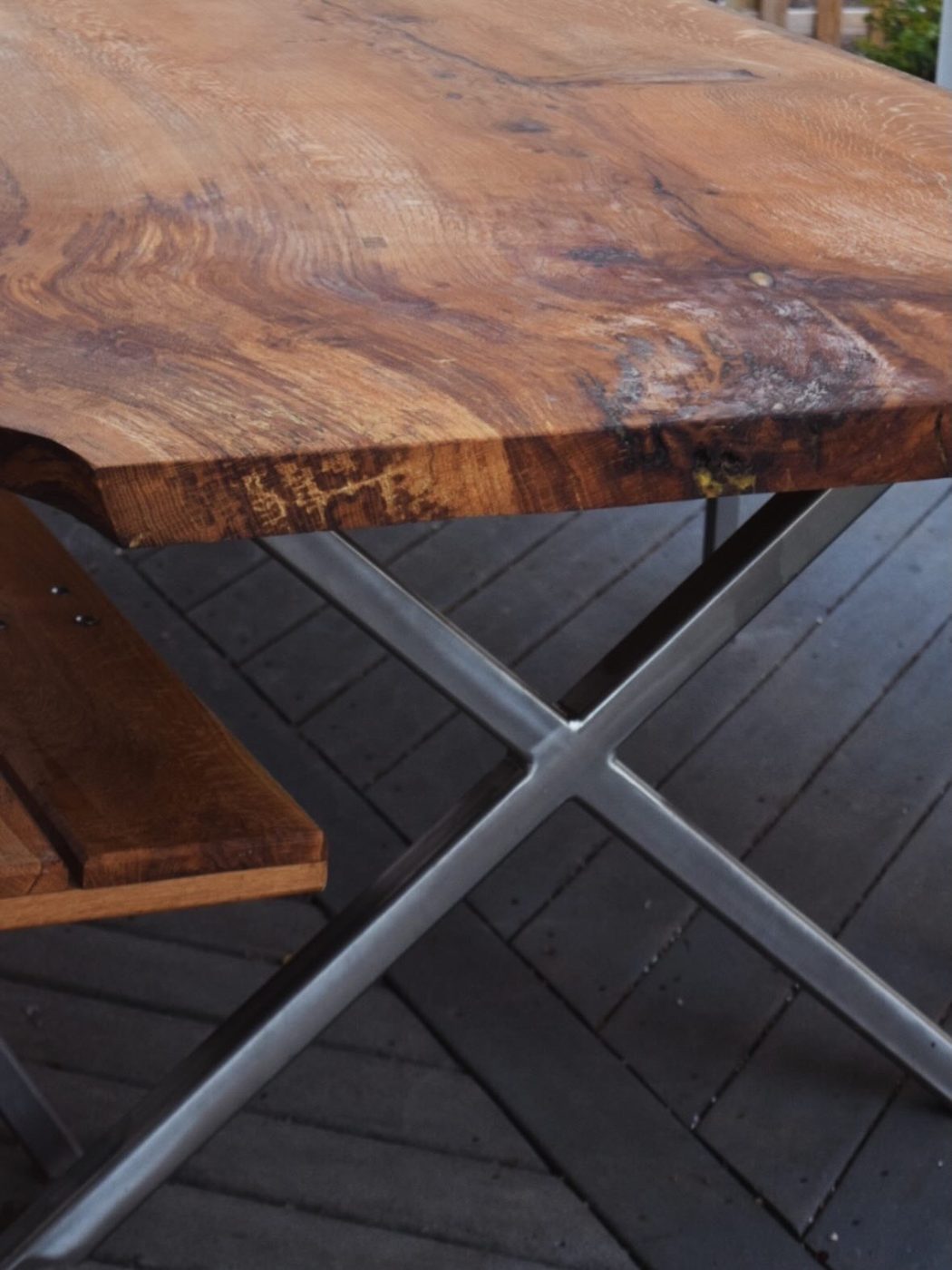 Detail of custom welded steel X-frame table leg